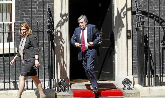 Britain's former PM Brown and wife Sarah leave after a lunch with Queen Elizabeth and PM Cameron at Downing Street in London