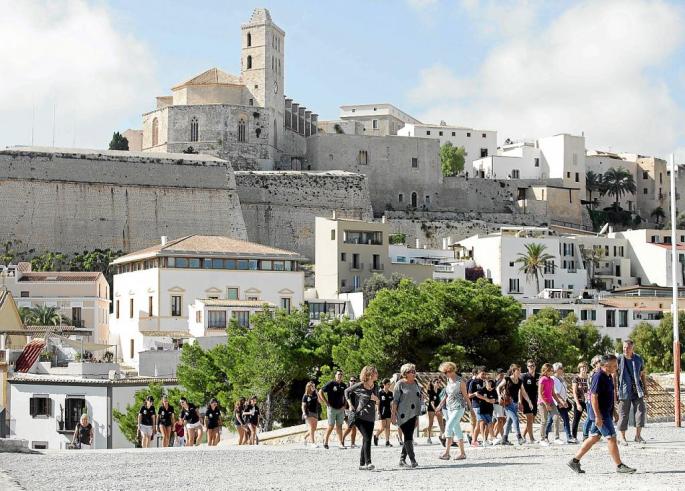 Un grupo de turistas pasea por el baluarte de Santa Llúcia con la catedral de Ibiza al fondo.