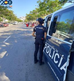 Una agente de la Policía Nacional junto a un furgón oficial.