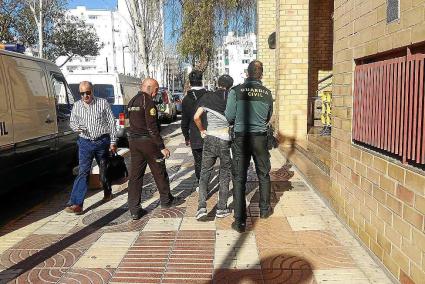 Un agente de la Guardia Civil acompaña a dos de los tres detenidos a la llegada a los juzgados.