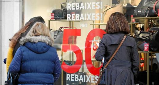 Varias mujeres paradas frente al escaparate de una tienda de complementos ayer, primer dÃ­a oficial de rebajas en Balears.